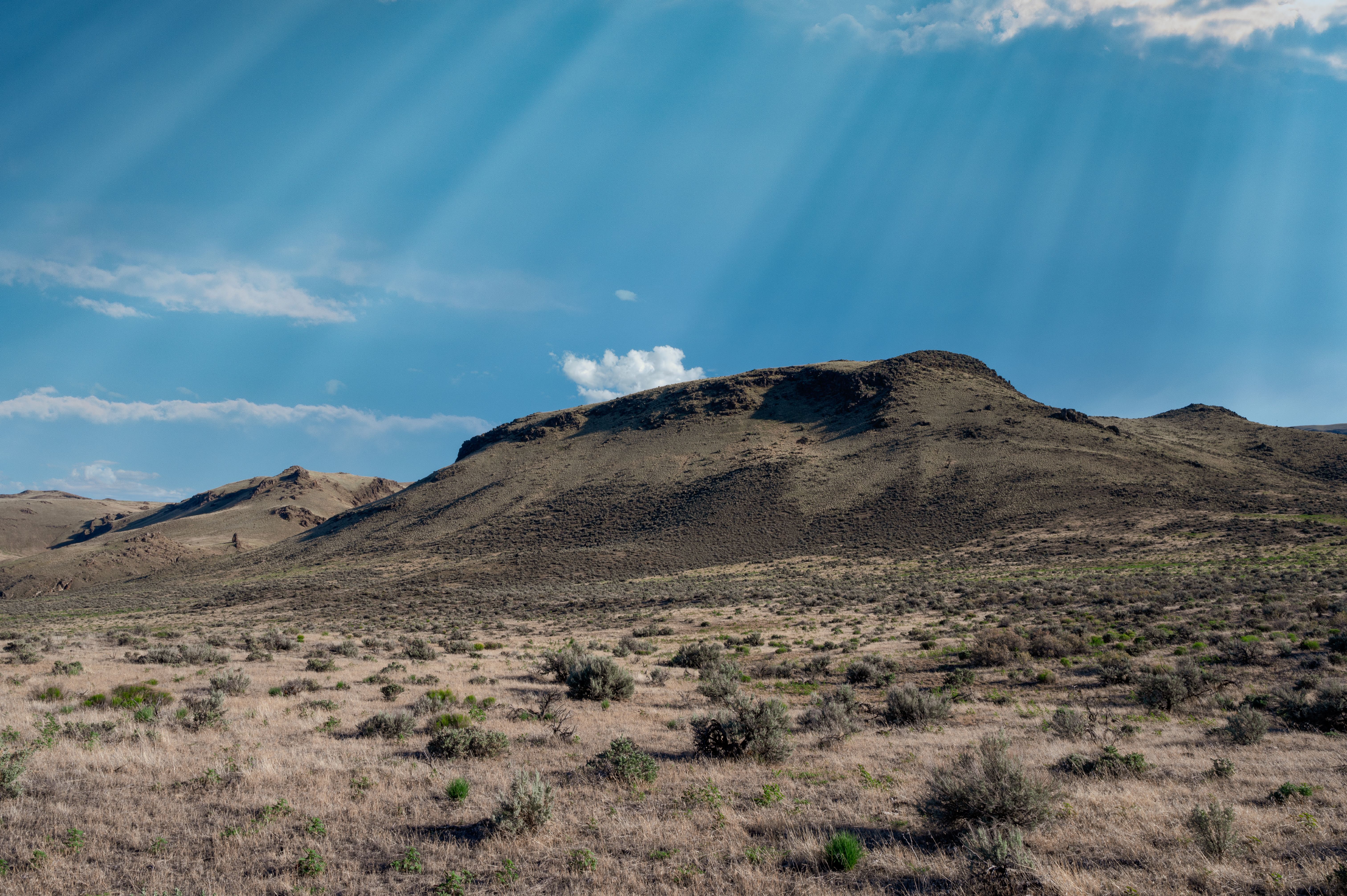 Desert near mountains under blue cloudy sky · Free Stock Photo