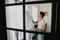 一位女士在现代办公室里，正专注地微笑着在白板上写字
