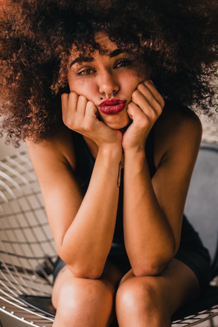 Unhappy Ethnic Woman Puffing Cheeks With Hands