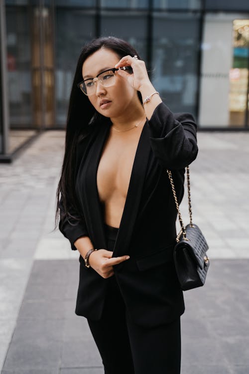 黑色皮夾克，戴著黑色鏡框眼鏡的女人