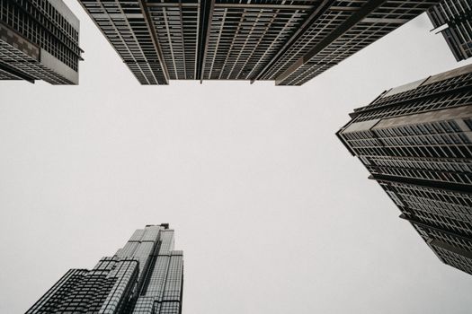 采用低角度拍摄现代城市摩天大楼与中性天空，展现城市建筑风貌