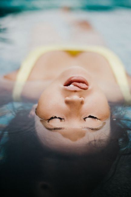 A serene depiction of a woman relaxing and floating in water.