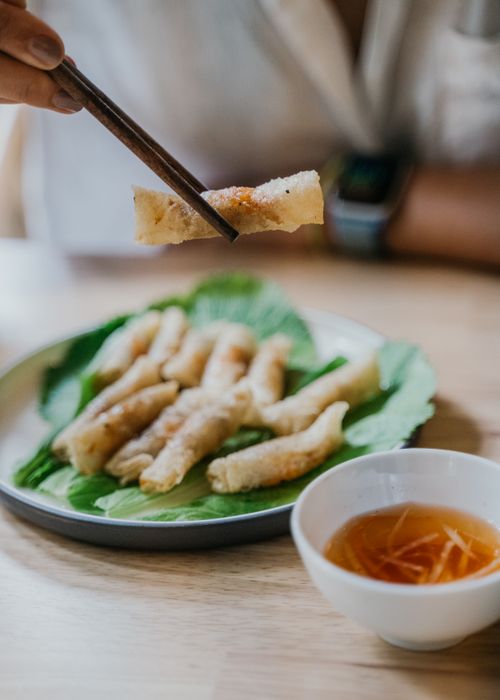 Free Close-up of delicious Vietnamese spring rolls with dipping sauce, perfect for food photography. Stock Photo