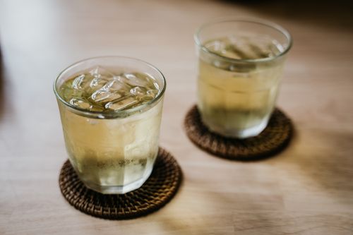 Free Two glasses of iced tea with ice cubes sit on coasters on a wooden table. Stock Photo