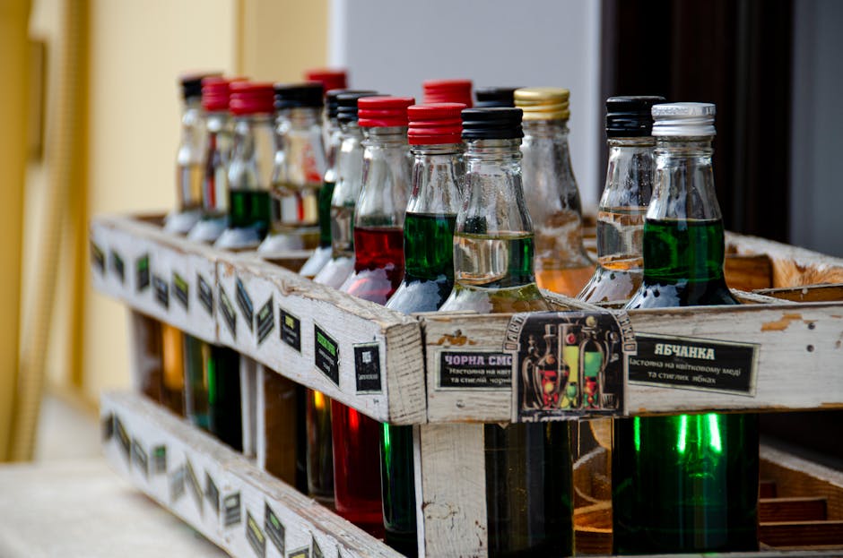 Vibrant assortment of bottles in a wooden crate with focus on variety and colors, perfect for beverage themes.