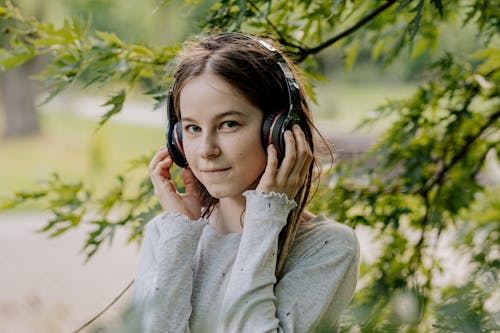 A Woman in Gray Sweater Listening with Headphone