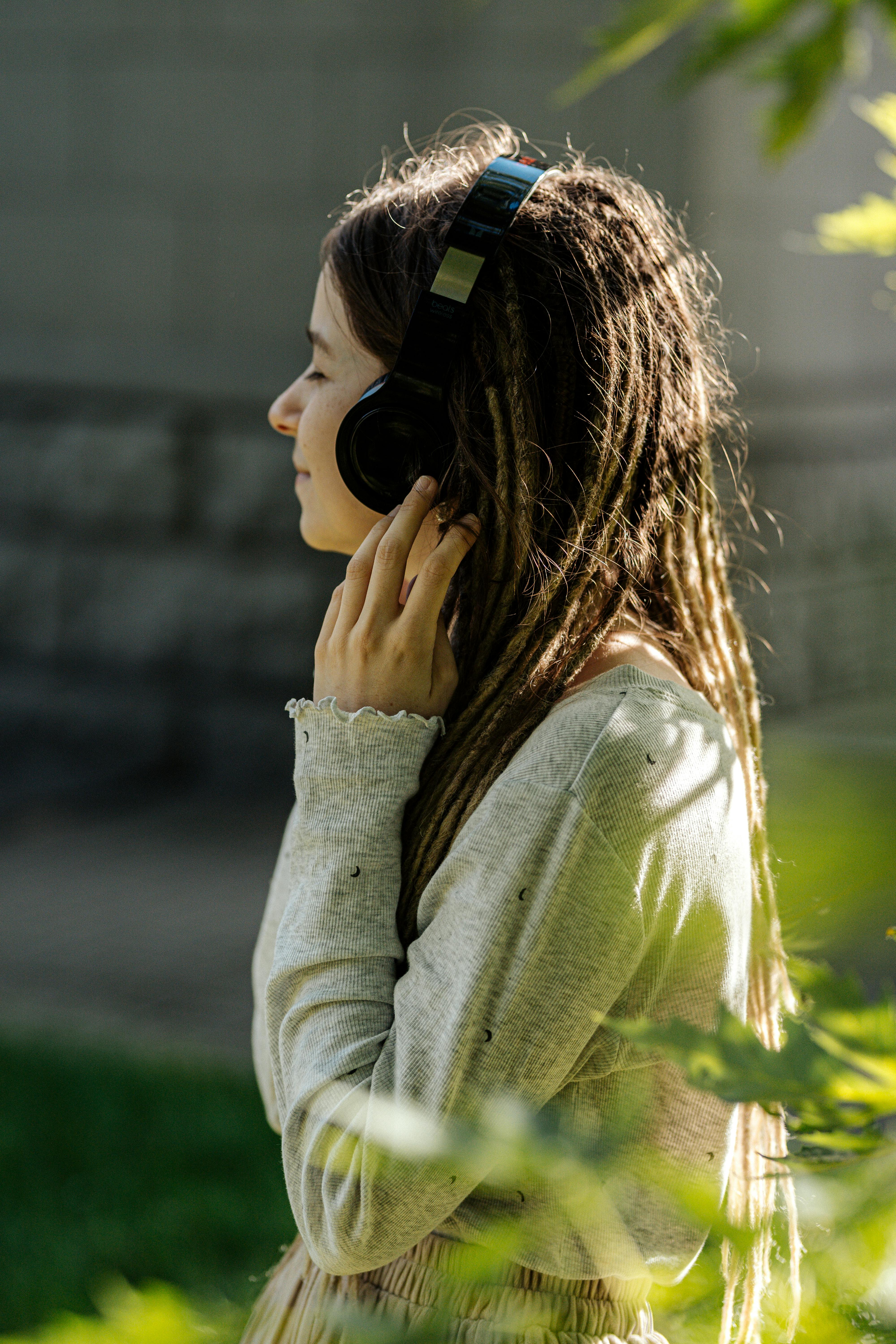 a girl in gray sweater wearing a headphone