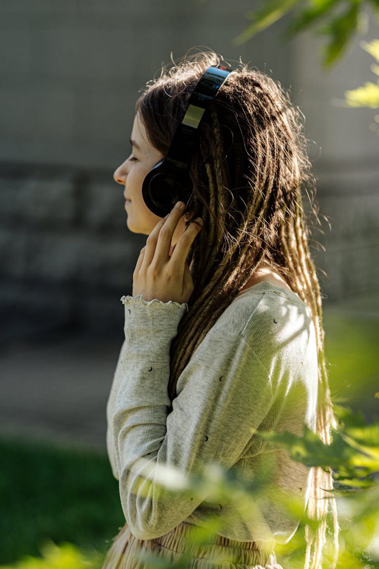 A Girl In Gray Sweater Wearing A Headphone