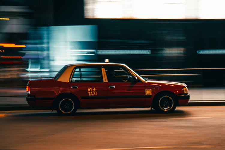 Vintage Taxi Car Driving On Street At Night