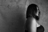 Plump black woman with bare shoulders smiling brightly
