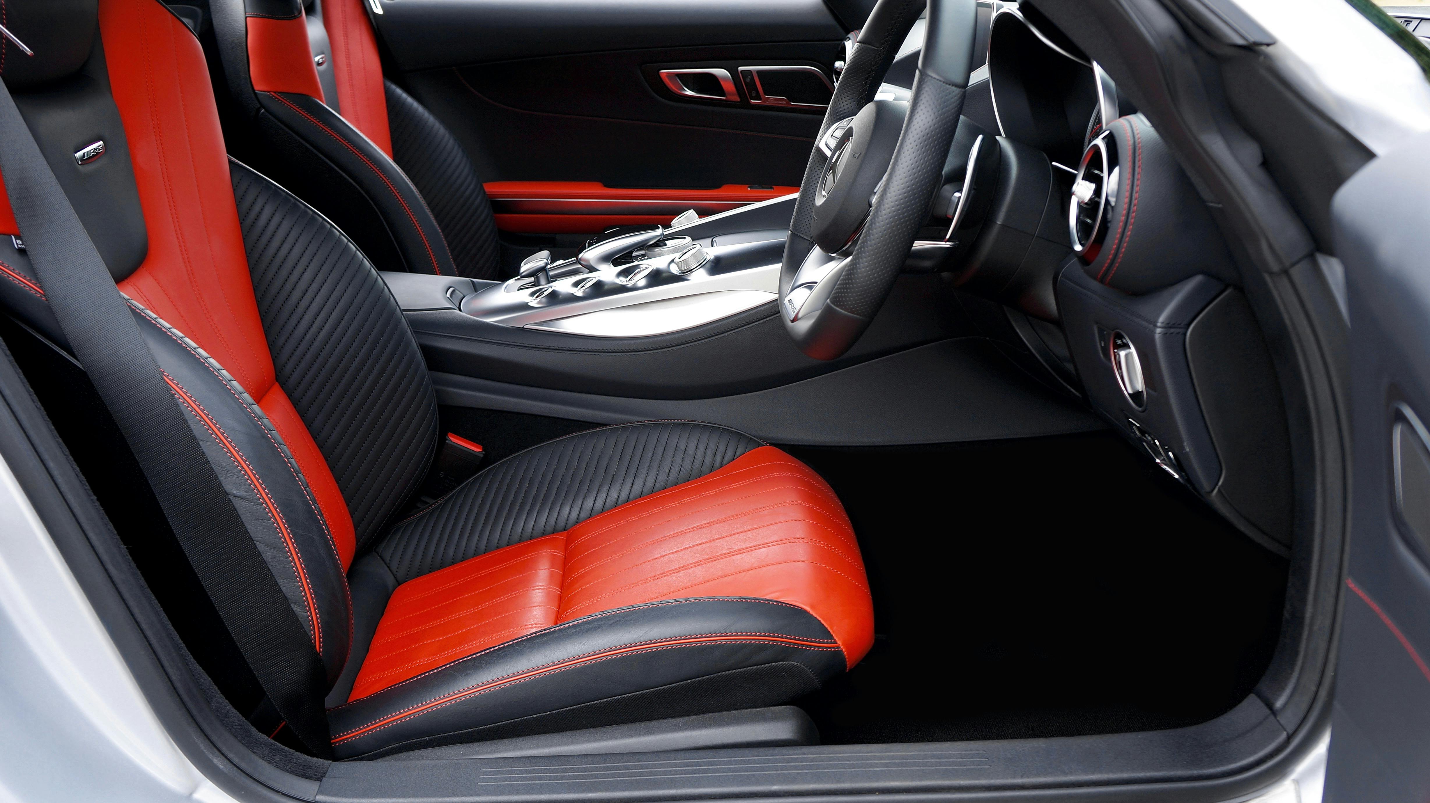 Modern luxury car interior showcasing red and black leather seats, emphasizing style and comfort.