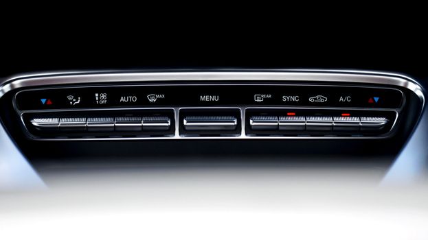 Close-up view of a sleek automotive dashboard climate control interface.