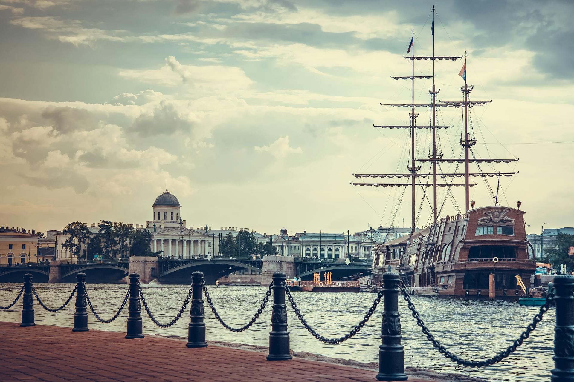 Picturesque harbor scene in St. Petersburg, featuring a historic ship and waterfront architecture.