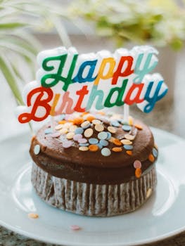 Delicious chocolate cupcake with sprinkles and colorful 'Happy Birthday' topper.
