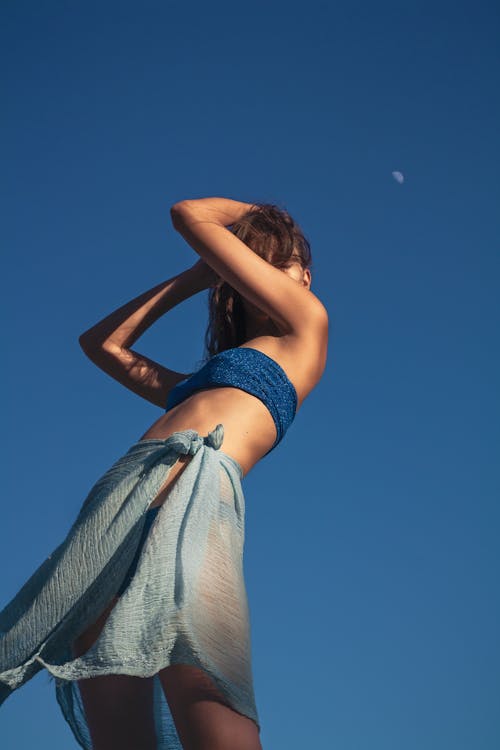 Woman in Blue Bikini Standing under Blue Sky