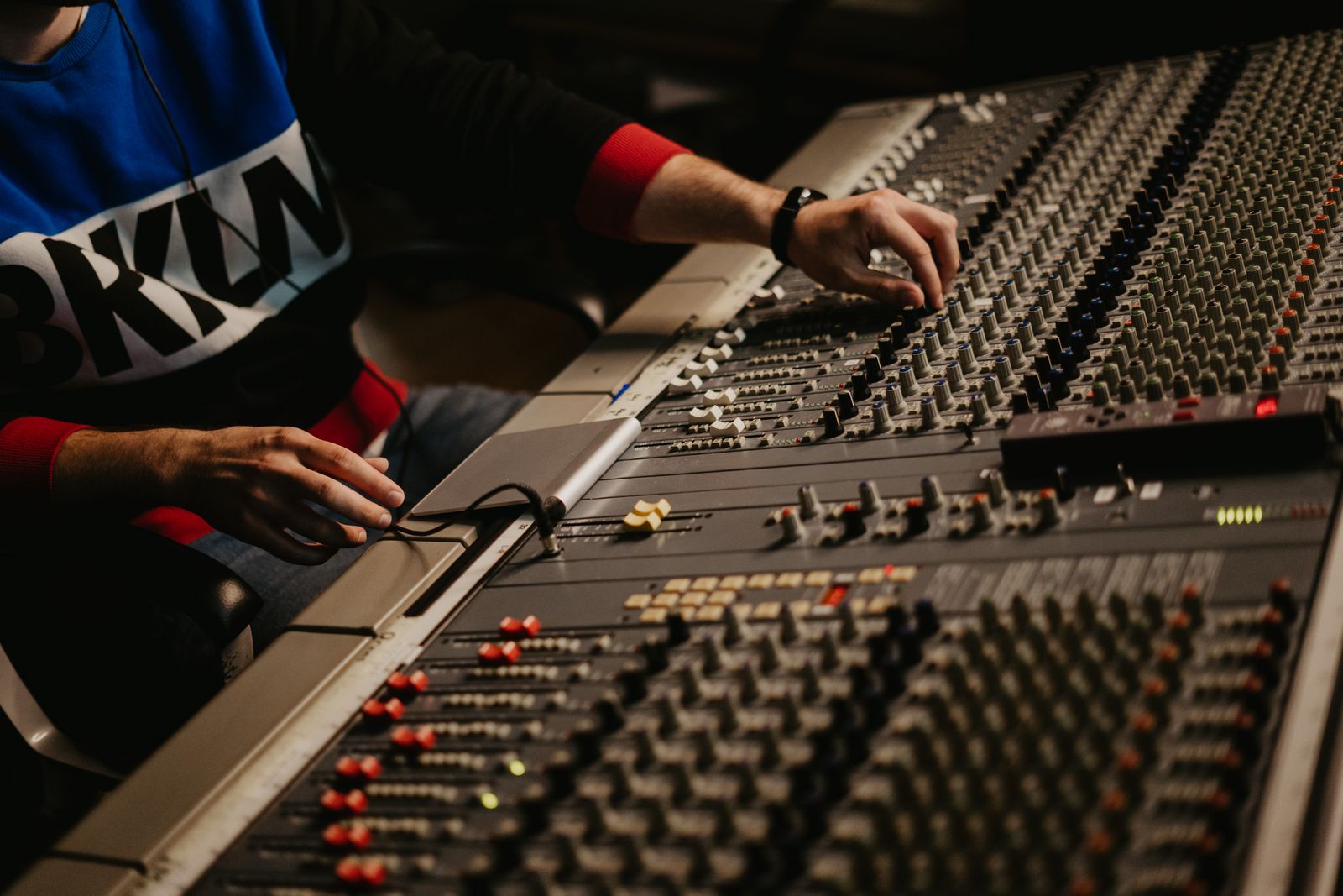 Sound engineer adjusting audio levels on a mixing console
