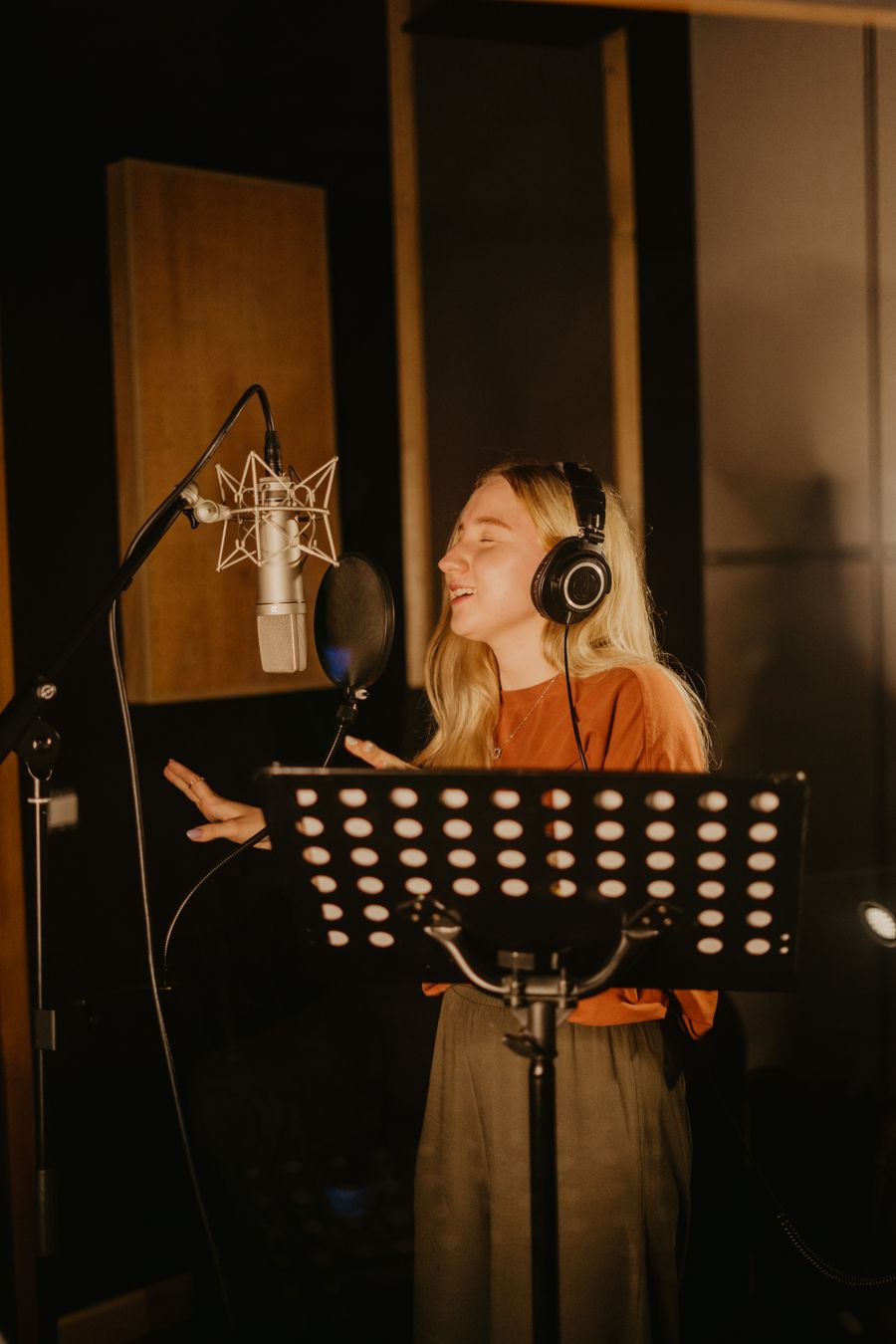 Chanteuse au casque en cabine d'enregistrement