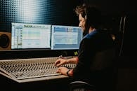A Man Wearing Headphone Controlling the Audio Equipment