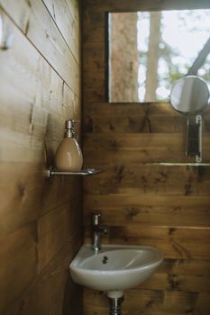 Cozy wooden bathroom interior featuring a modern white sink and mirror.