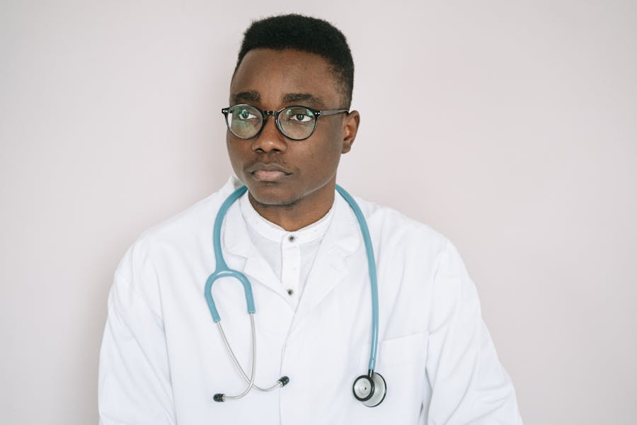 African male doctor writing notes in a clinical setting