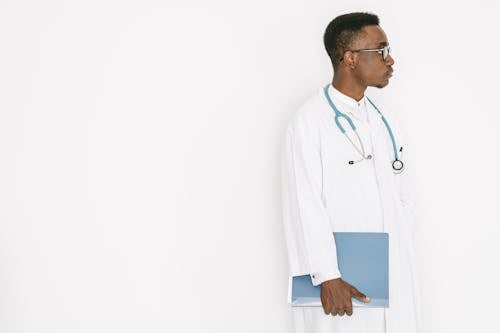 A Man in a Medical Gown Carrying a Folder