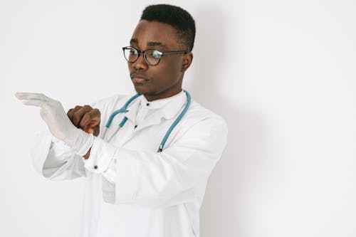 Free A Man in Medical Gown Wearing a Glove Stock Photo