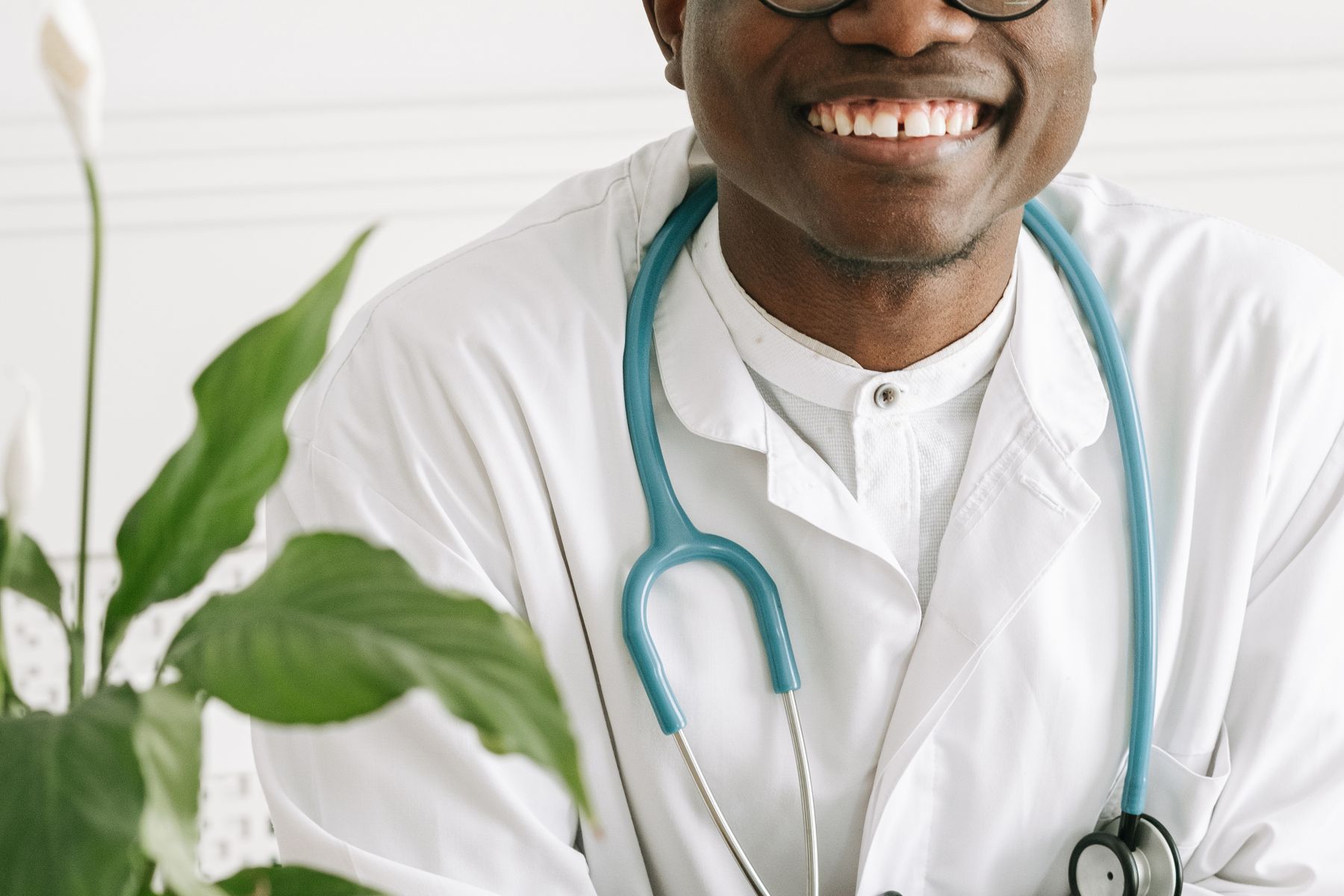 Smiling male doctor working with a laptop in a bright office