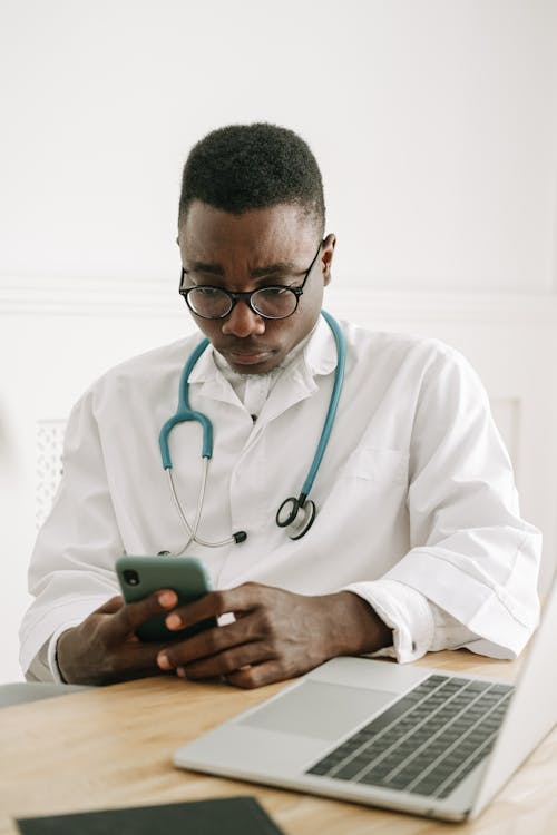 Free A Doctor Using a Smartphone Stock Photo