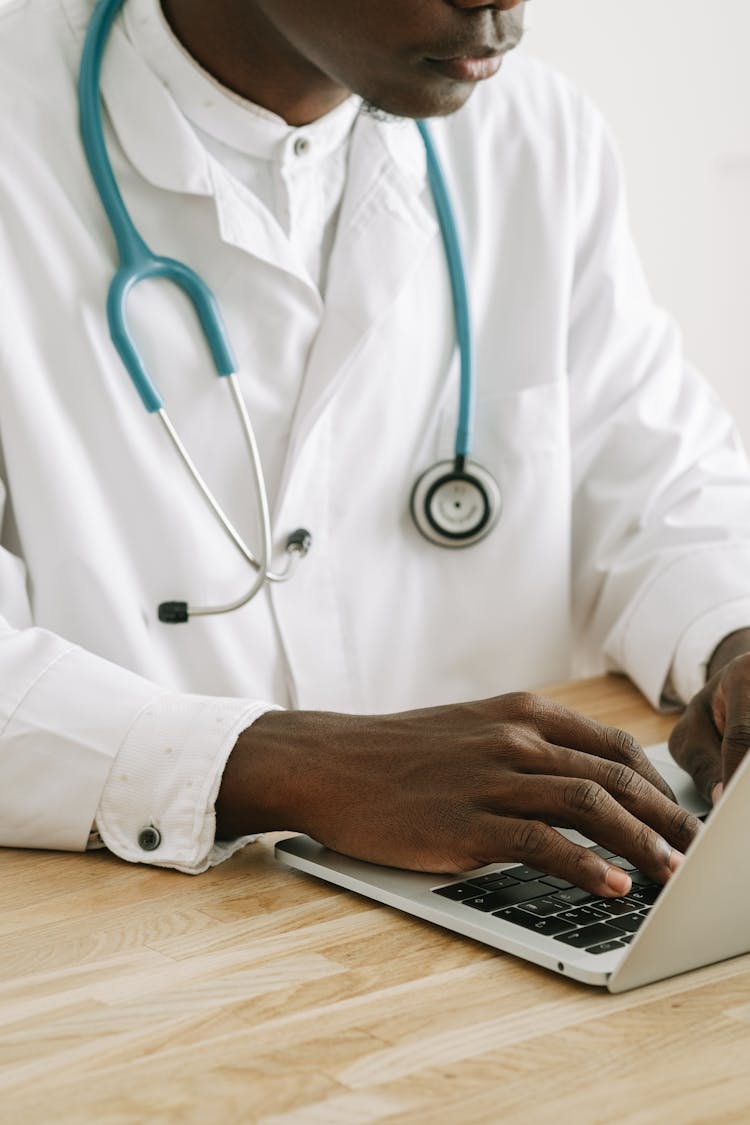 A Doctor Typing On Laptop