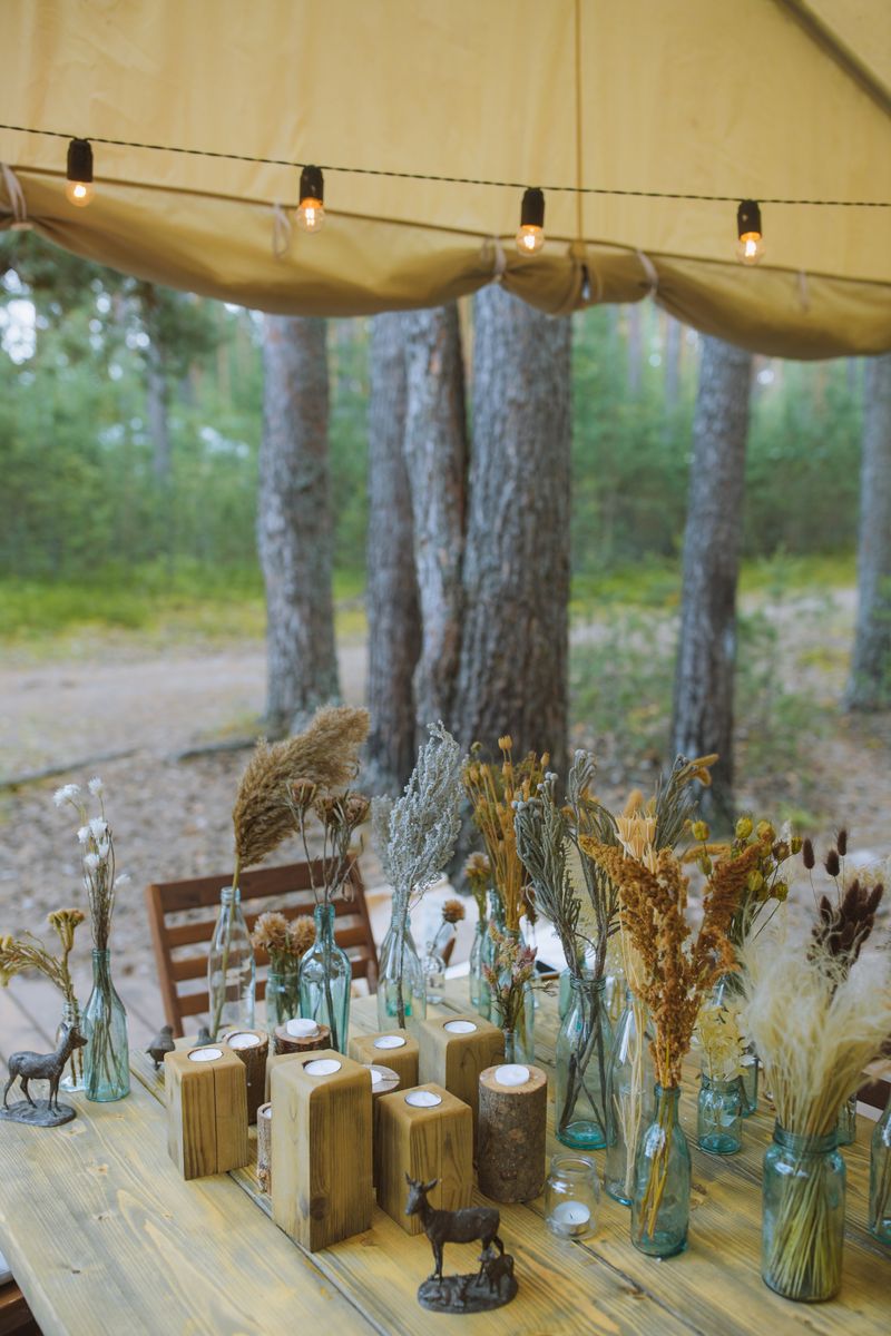 Rustic woodland table setting with greenery and wood elements