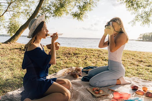 两名女子在湖边野餐，品尝寿司并捕捉瞬间