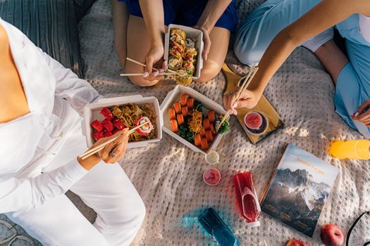 A casual outdoor picnic featuring Asian cuisine and sushi, perfect for a relaxed day out.