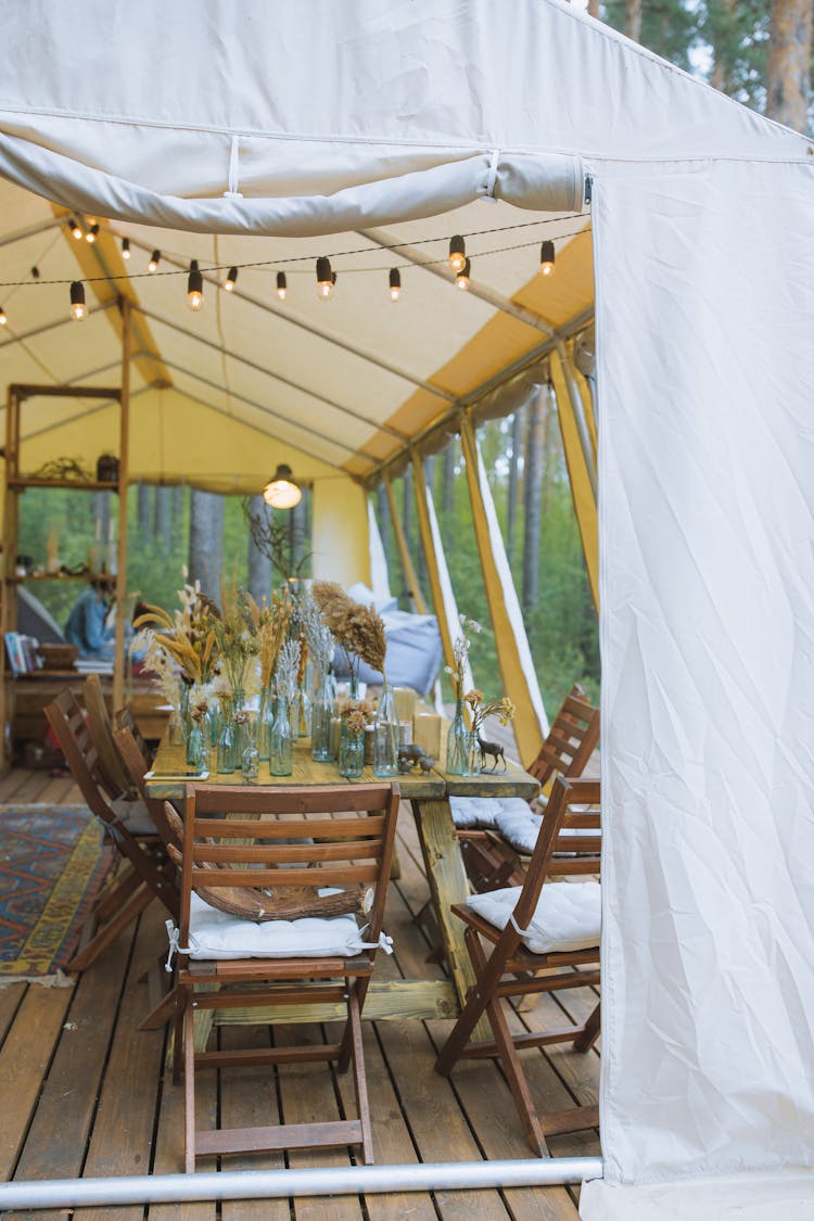  Wooden Chairs And A Table Inside A Tent