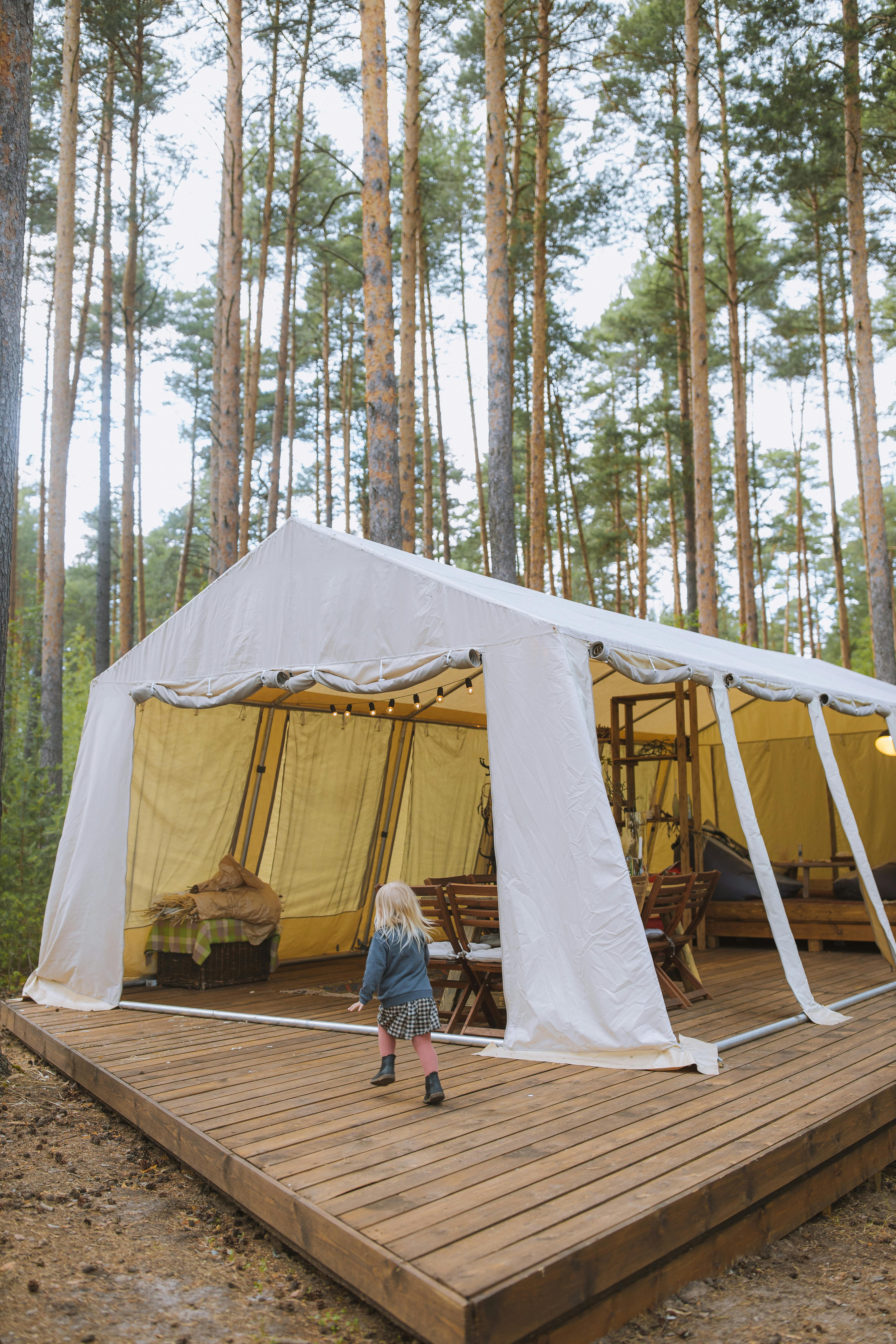 a child running on a wooden deck with a tent