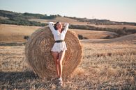 Woman in White Dress Standing on Brown Grass Field