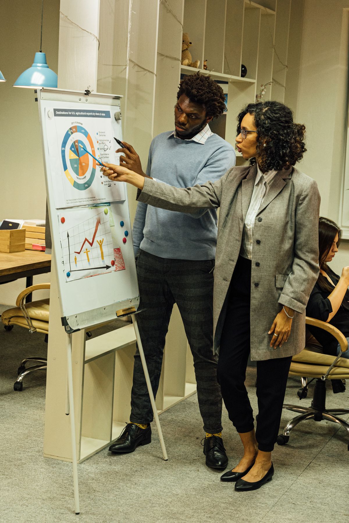 Two colleagues discussing business charts during a data-analysis meeting