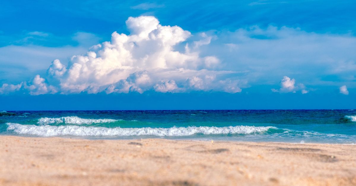 Beautiful sandy beach scene at North Topsail Beach, NC with waves and bright sky.