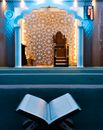 Open Book on Carpet with Elements of Islamic Architecture in Background