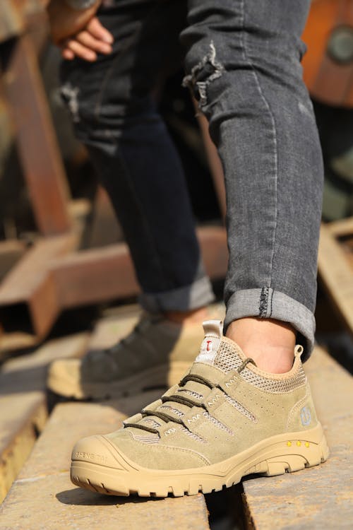 A Person Wearing Black Denim Jeans and Brown Lace Up Shoe