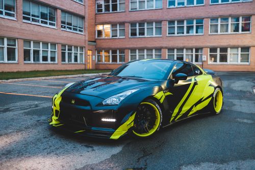 Free Sparkling automobile with tinted lines parked on concrete road in yard of brick stone building Stock Photo