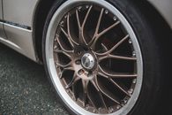Closeup of chrome wheel disk of stylish retro automobile parked on asphalt concrete road