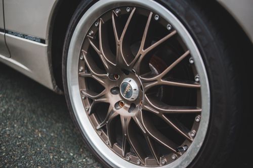 Free Closeup of chrome wheel disk of stylish retro automobile parked on asphalt concrete road Stock Photo