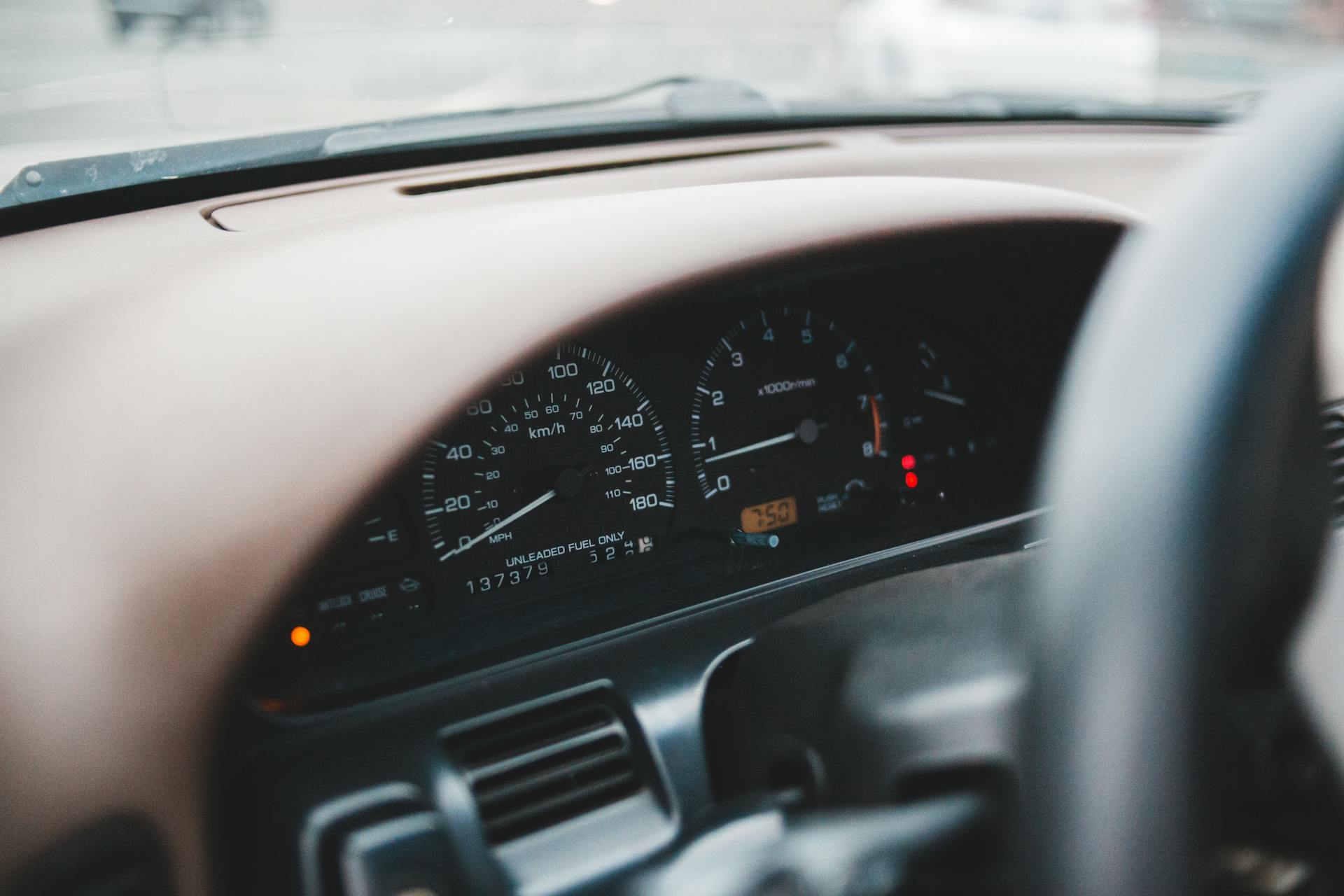 Closeup of control panel of modern expensive automobile with indicators on wide dashboard in soft focus