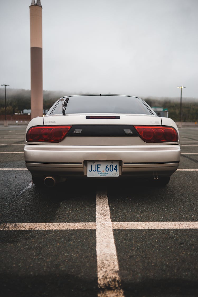 Vintage Car With Pipe Parked On Asphalt Surface