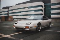 Retro automobile parked on paved road with marking lines near modern house with glass wall in city center in daylight
