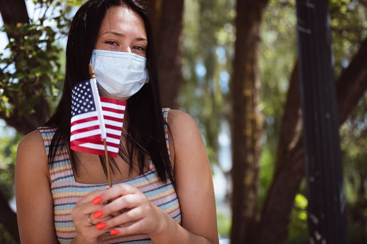 Unrecognizable Woman In Mask With National Flag Of America