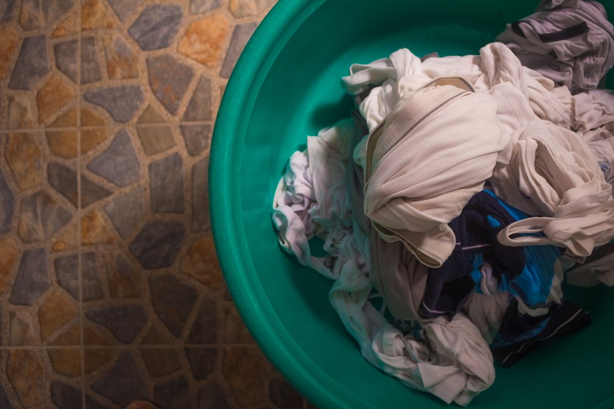 Overhead view of a laundry basket piled with crumpled washing waiting to be sorted