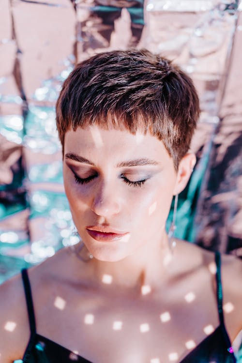 Calm woman with bright glitter on body