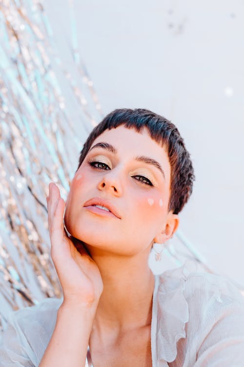 Young attractive woman near wall with silver decoration