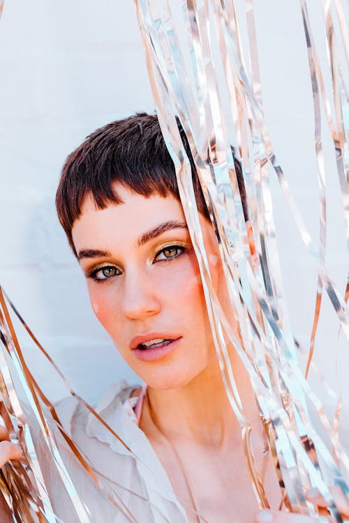 Dreamy woman standing behind tinsel